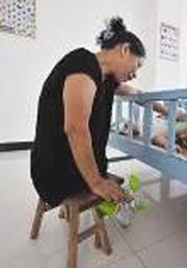 مبتورة الساقين.. تمشي على مقعدين خشبيين وتربي 130 يتيماً!